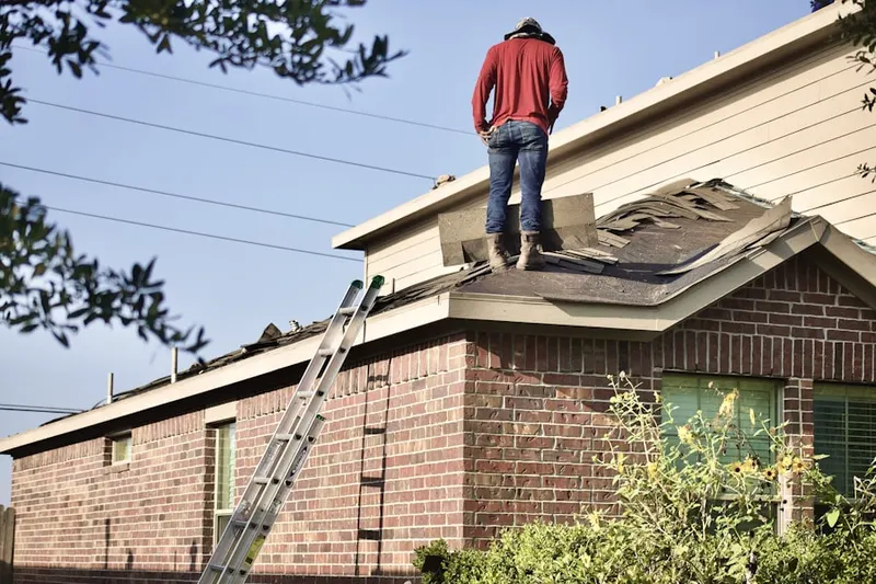 Professional roofer working on a residential roof in Belle Farm Heritage